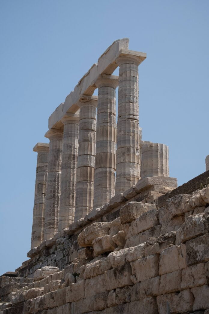 lifeofpix-qt1-310766 Remains of the Temple of Poseidon at Cape Sounion, featuring the iconic white marble columns and partial structure against a scenic coastal backdrop, illustrating the temple's ancient grandeur and architectural significance